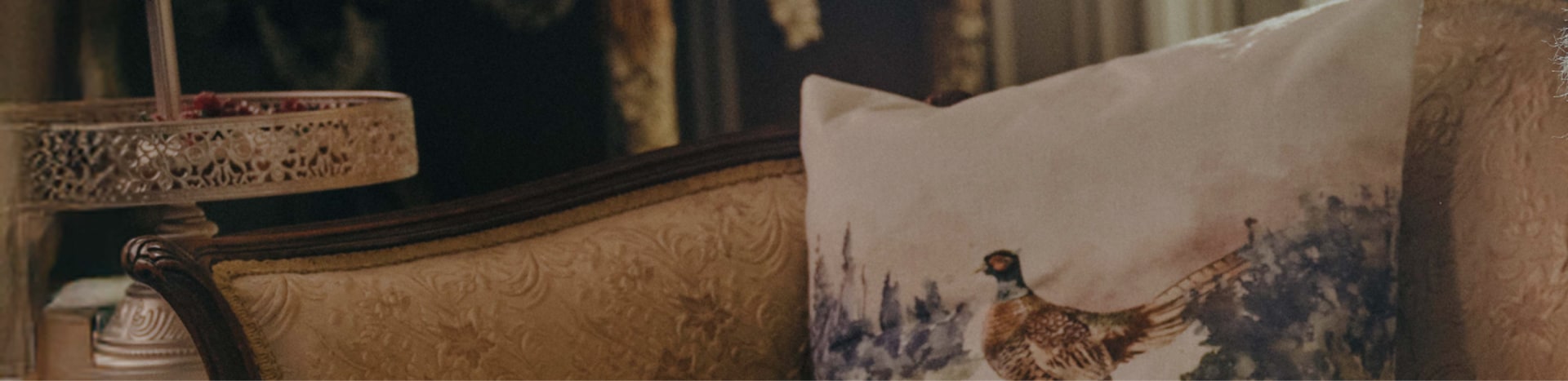 A close-up of a vintage sofa with a decorative pillow featuring a pheasant design. Text over the image reads: “CLOT Stan Smith Collection by EC”.