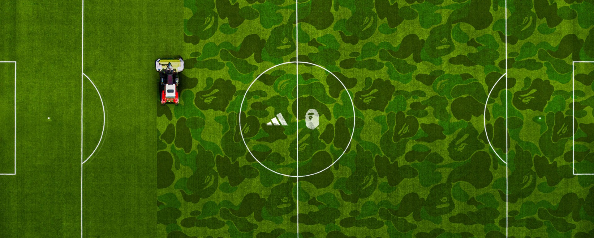 A soccer field with a camouflage pattern in the background, and a small toy car on the field.