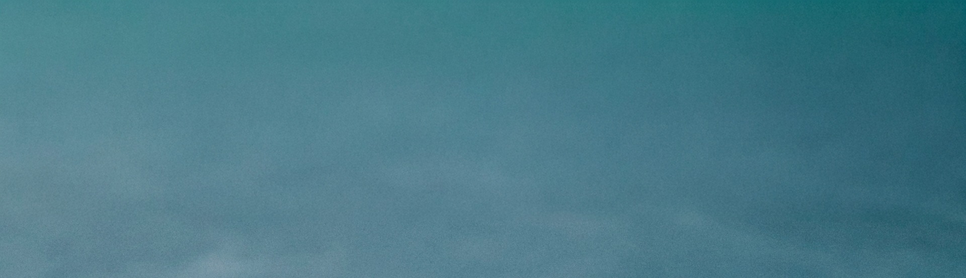 A solid teal blue background fills the entire frame, creating a simple and minimalist visual.