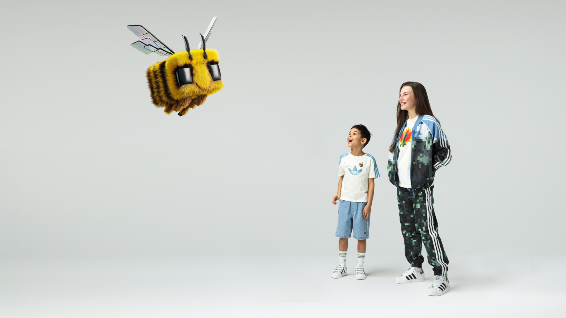 A woman and a little boy are looking at a flying Minecraft bee in awe. 