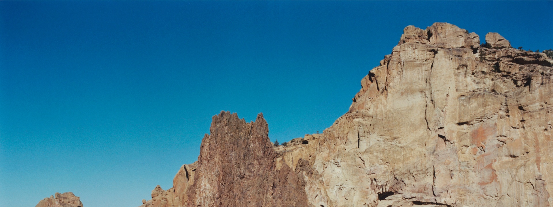 Towering, rugged rock formations stand against a vibrant blue sky, creating a dramatic and awe-inspiring landscape.