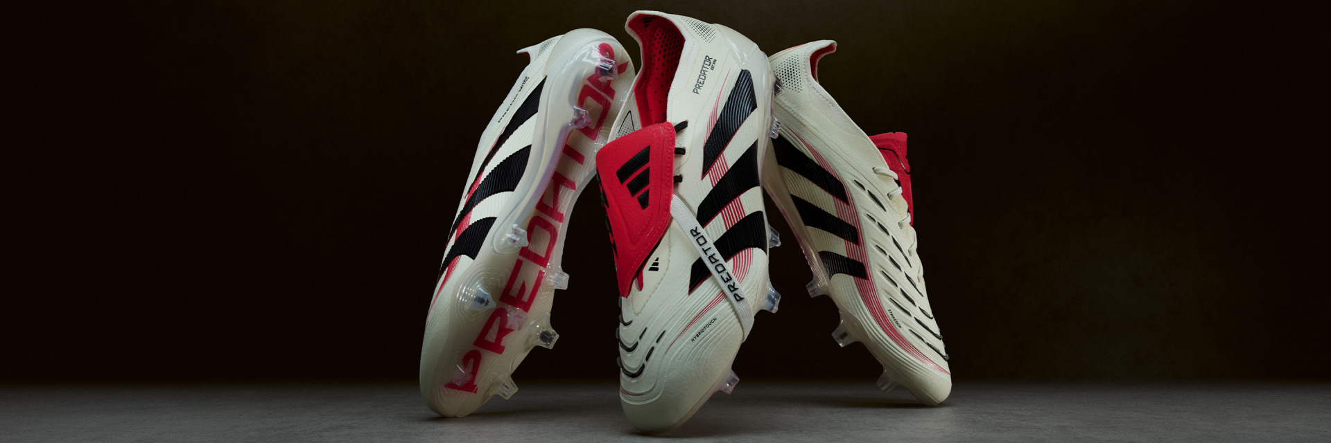 A pair of white and red sports shoes with distinctive patterns and designs, set against a dark background.