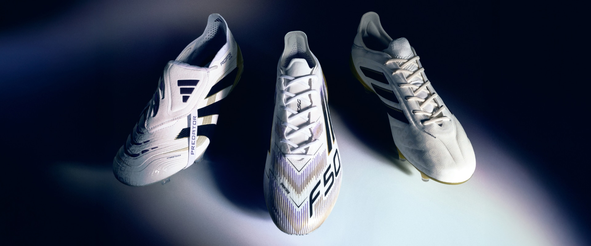 Three pairs of white and black soccer boots with intricate designs and patterns are displayed against a dark background, creating a striking and visually appealing composition.