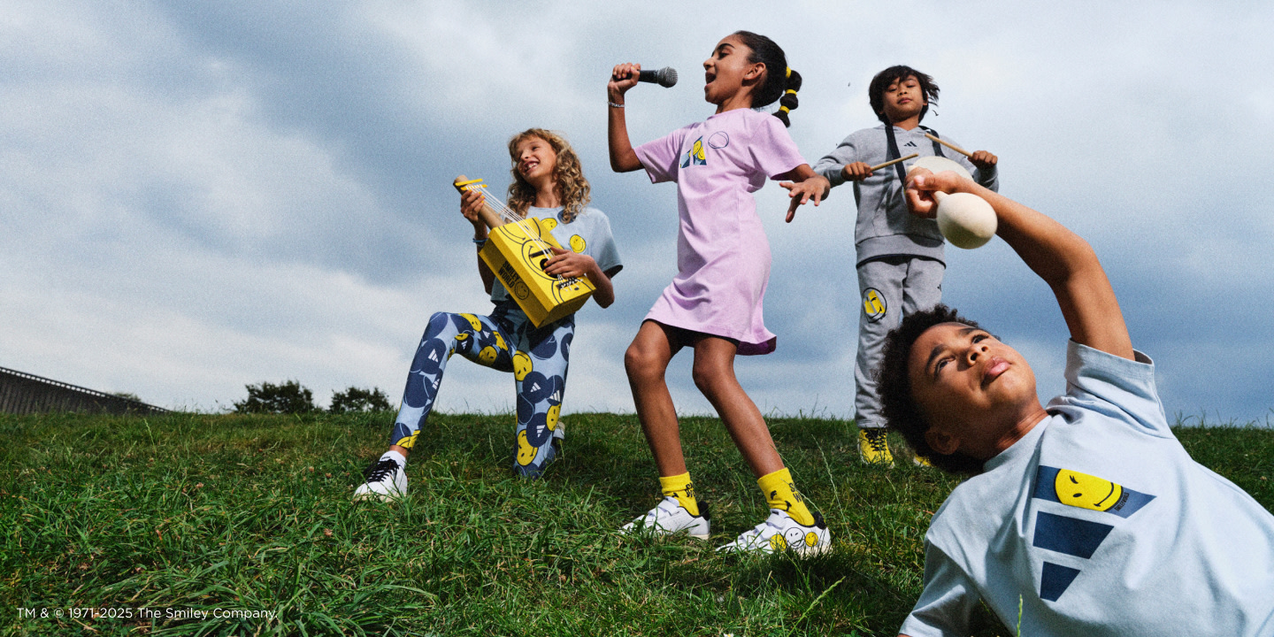 Four kids wearing adidas | Smiley sportswear play musical instruments together on the grass.