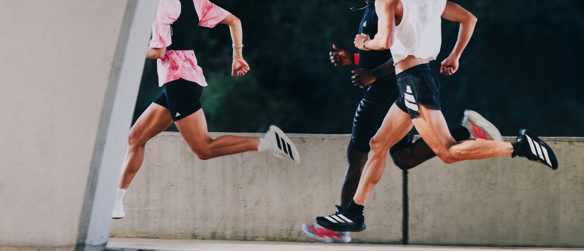 The image depicts several people engaged in a physical activity, with their legs and feet visible in the foreground against a dark background.