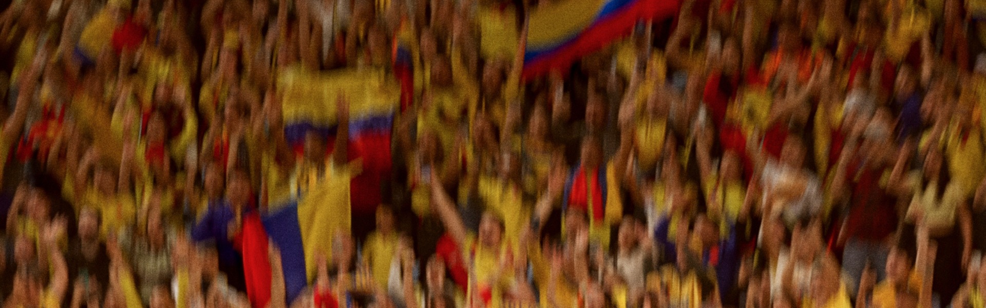 A vibrant and abstract composition of blurred, overlapping shapes in warm hues of red, yellow, and blue, creating a dynamic and visually striking pattern.