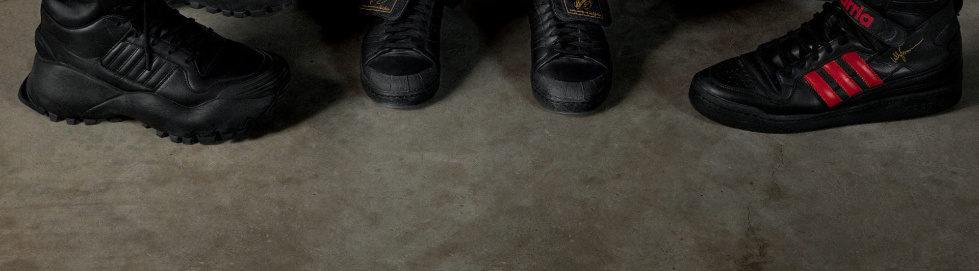 Black leather boots on a concrete floor, with a dark, shadowy background.