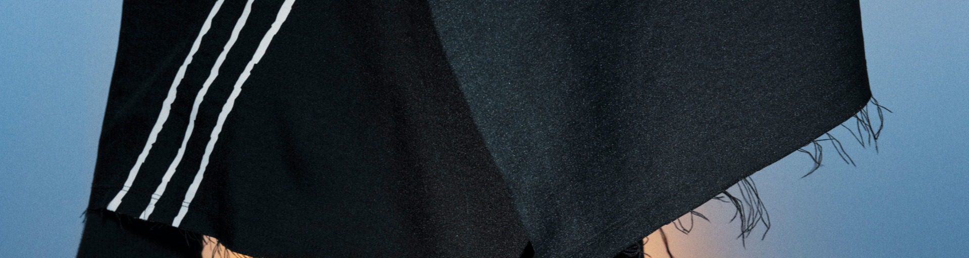 A dark, woollen fabric fills the frame, with a lighter, textured material visible in the background.