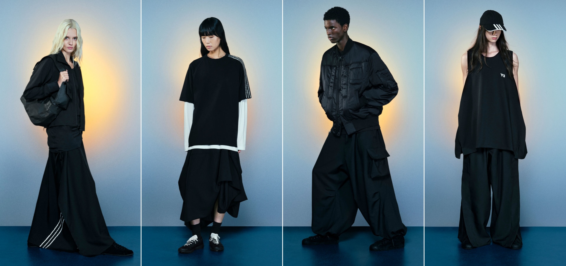 単色や淡色の背景の前に、オールブラックでドラマティックなファッションを着た4人の人物が立っている。