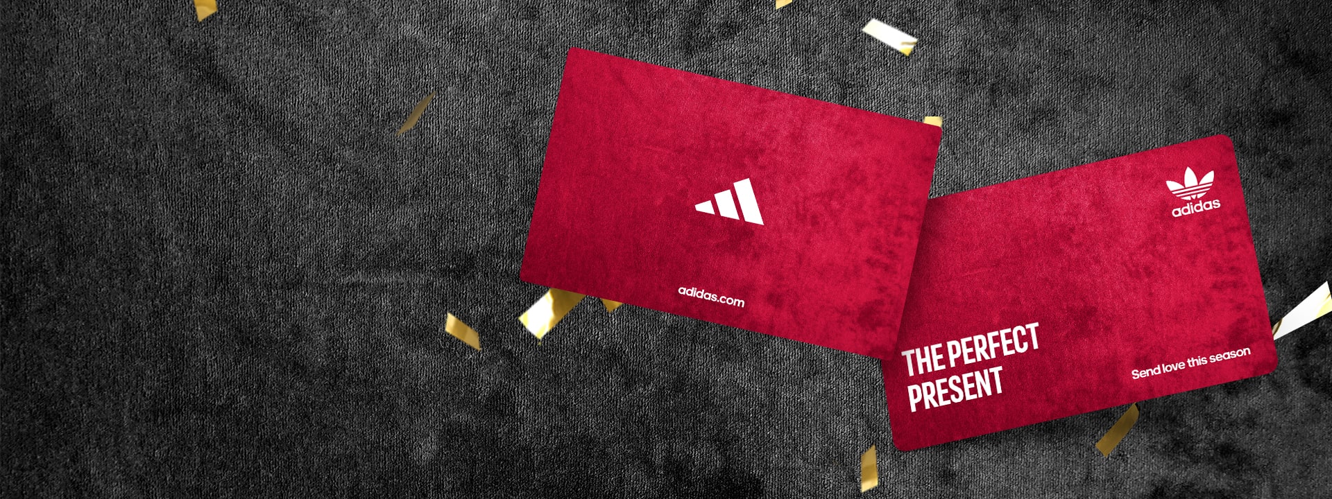 A red Adidas box with the text "THE PERFECT PRESENT" lies on a dark background with scattered yellow confetti.