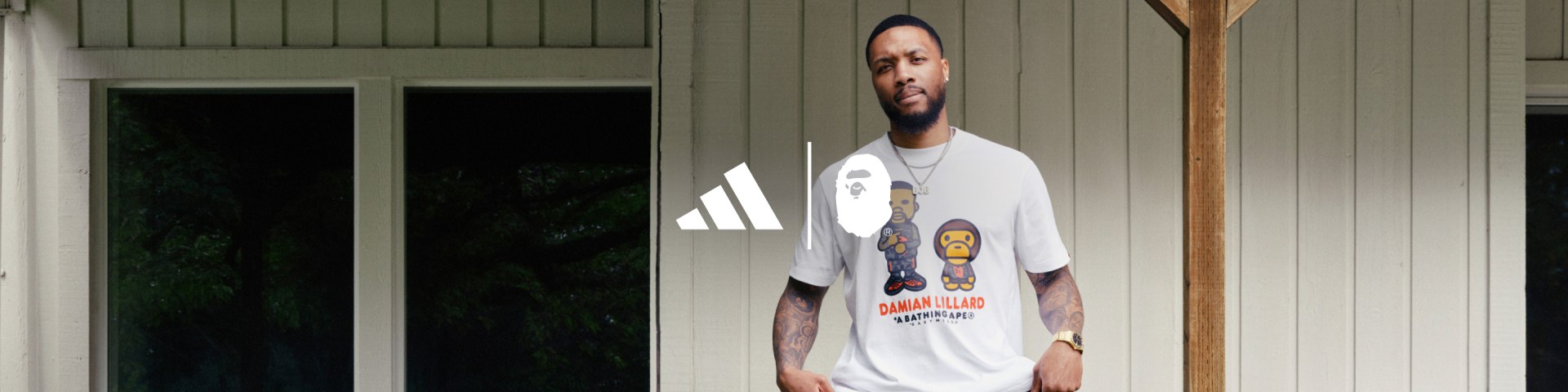 Damian Lillard poses in the new adidas BAPE Dame 9 collection in front of a house with white walls.