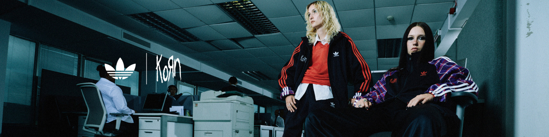 Models rock the adidas Originals x KoRn collection in an office environment.