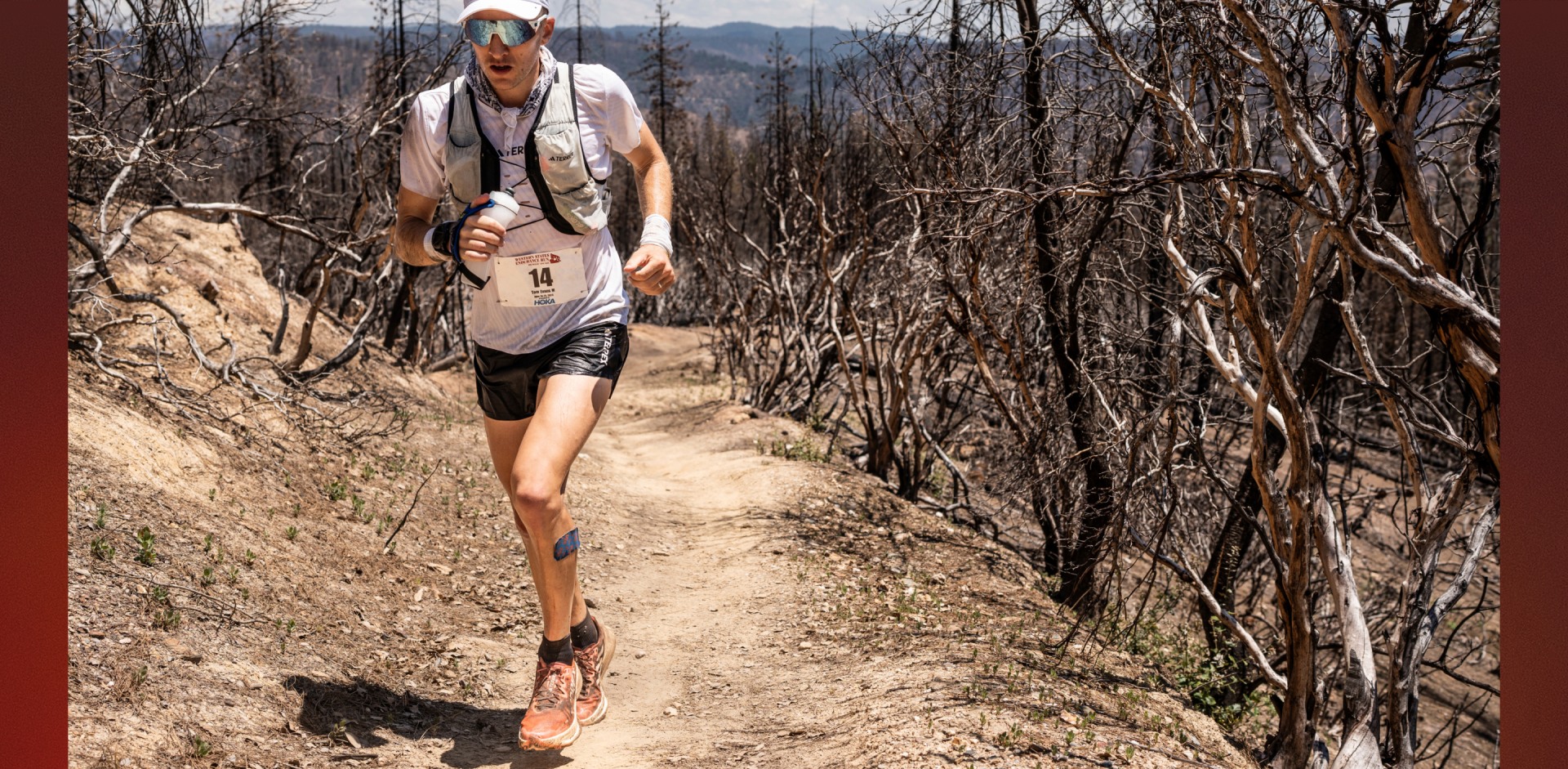 An image of adidas TERREX athlete Tom Evans, running on a sunny mountainous trail wearing shoes and apparel from the new Agravic range.
