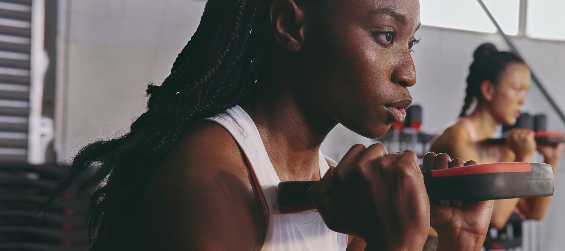 A young person with braided hair is intently focused, their face in close-up against a blurred background.
