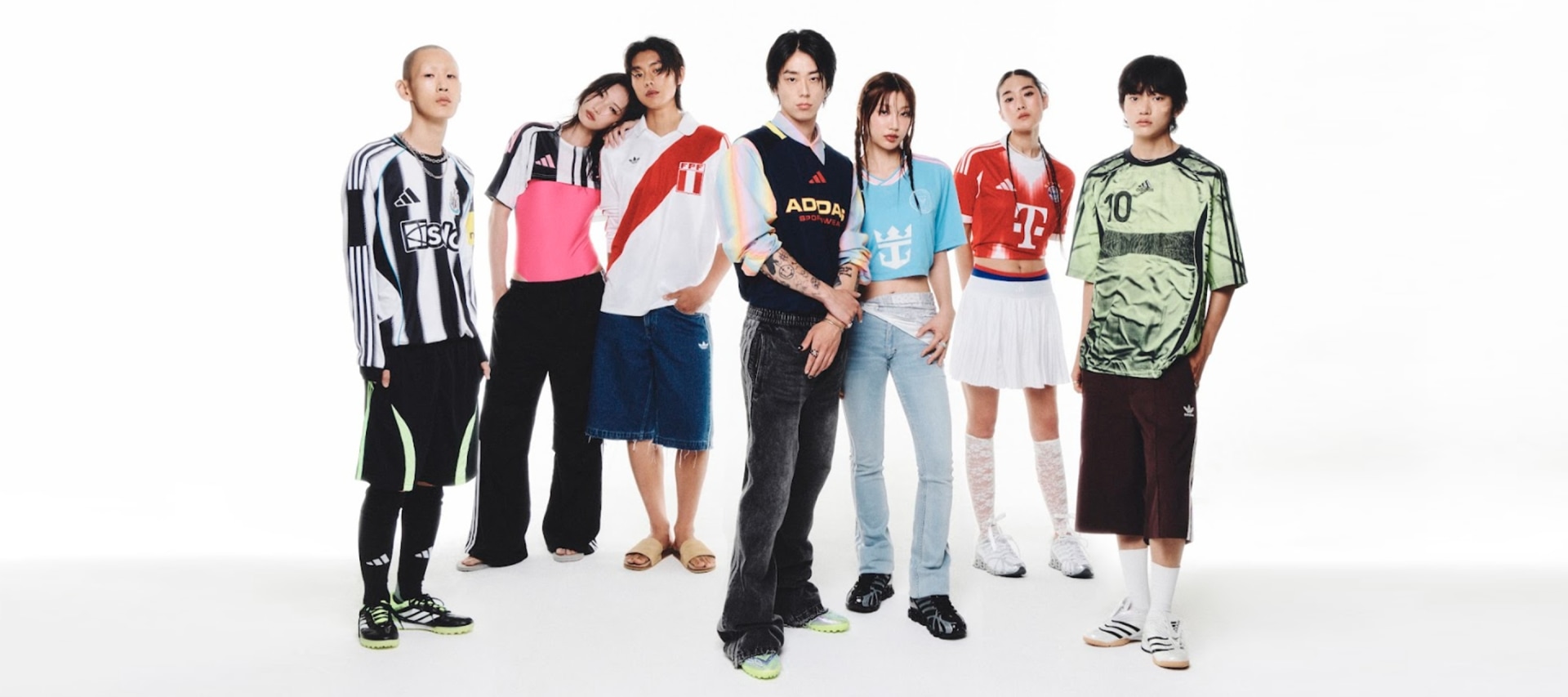 A group of diverse individuals, dressed in a variety of casual and athletic attire, standing together against a plain white background.