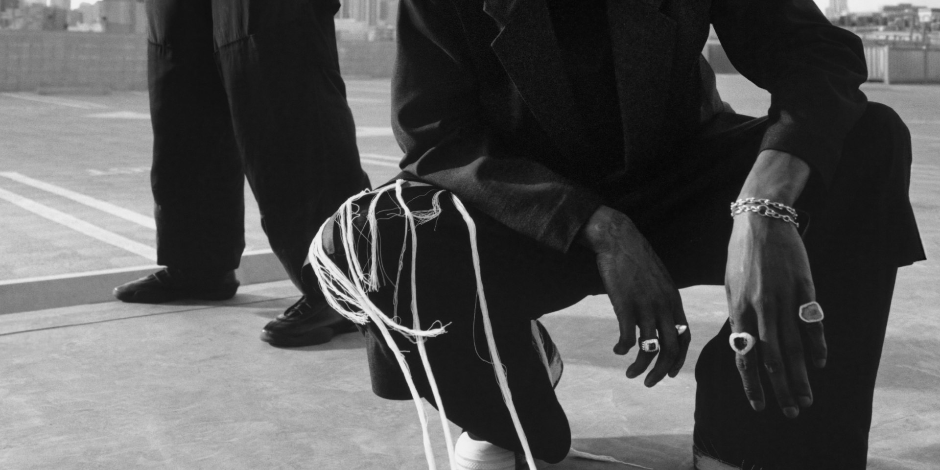 A$AP Nast and Noah Lyles stand on an LA rooftop in a black-and-white photo, dressed in adidas Y-3 and gazing intently into the camera.