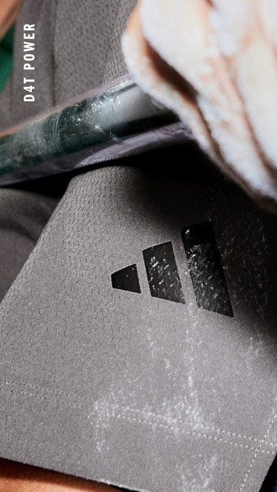 Das Bild zeigt eine Nahaufnahme einer grauen, strukturierten Oberfläche mit einem kleinen, dreieckigen Symbol oder Logo in der Mitte.