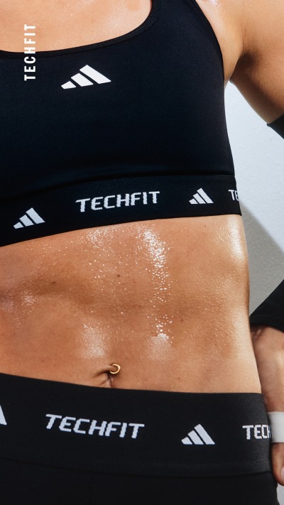 Das Bild zeigt einen Mittelfeldspieler in schwarzer Sportbekleidung mit dem „TECHFIT“-Logo auf der Brust.