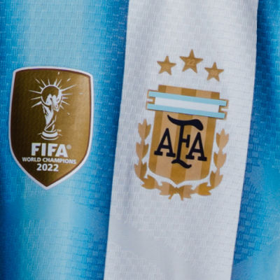 The image shows the FIFA World Champions 2022 logo and the Argentine Football Association (AFA) logo on a light blue background.