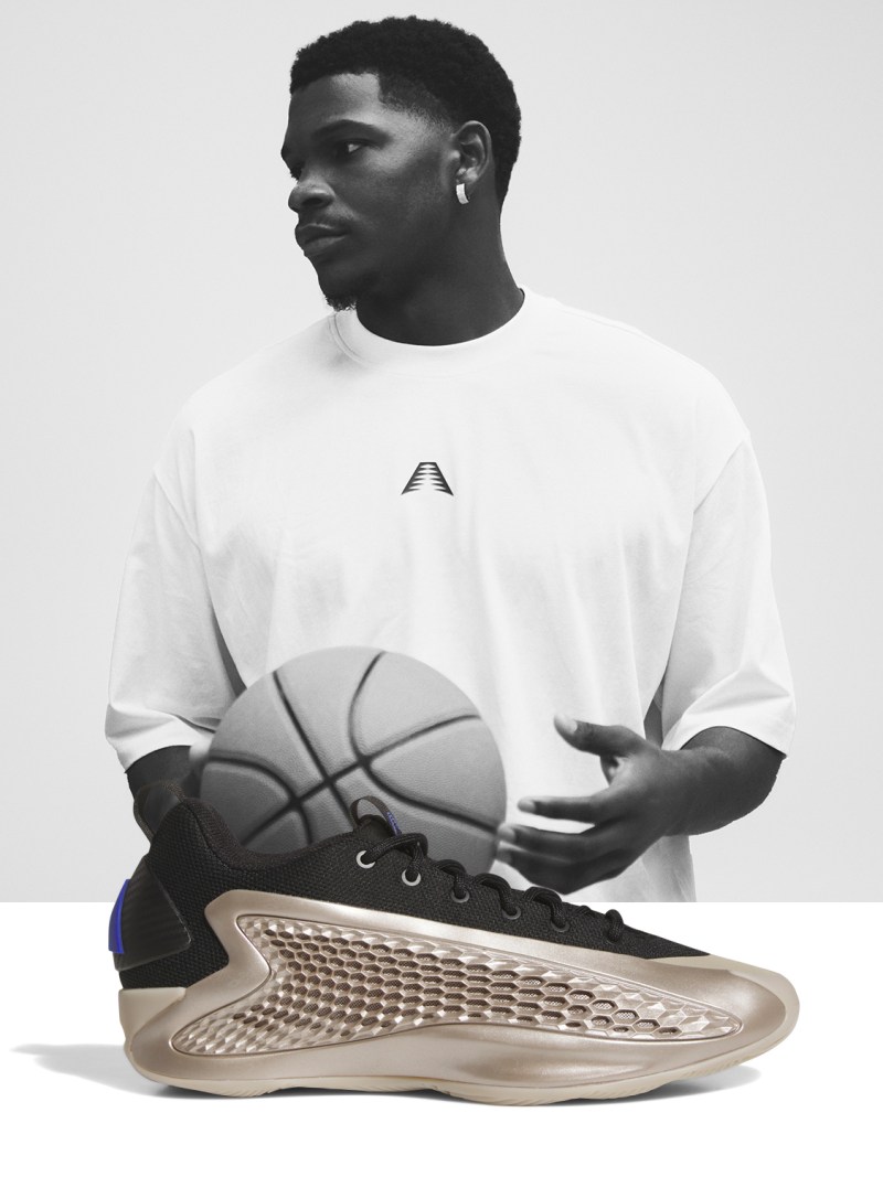A young man wearing a white t-shirt holds a basketball in front of a pair of futuristic-looking sneakers on a plain background.