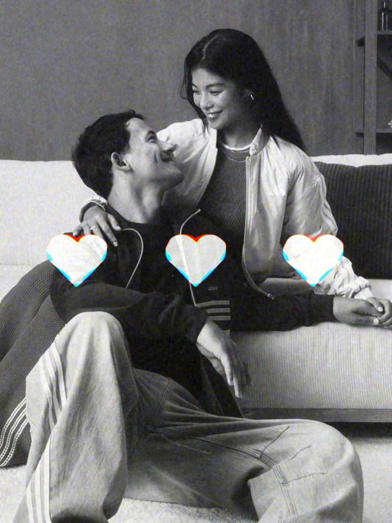 Ett svartvitt fotografi fångar ett ömt ögonblick mellan en man och en kvinna, som verkar vara i en nära, intim omfamning i en soffa eller säng.