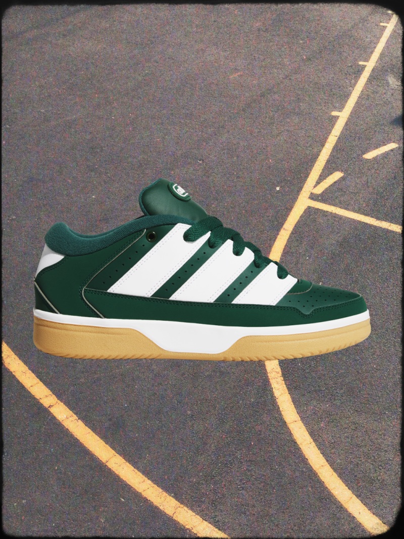 Las líneas amarillas de las zapatillas verdes y blancas se asientan sobre una superficie pavimentada, sugiriendo una pista deportiva o un campo de juego.