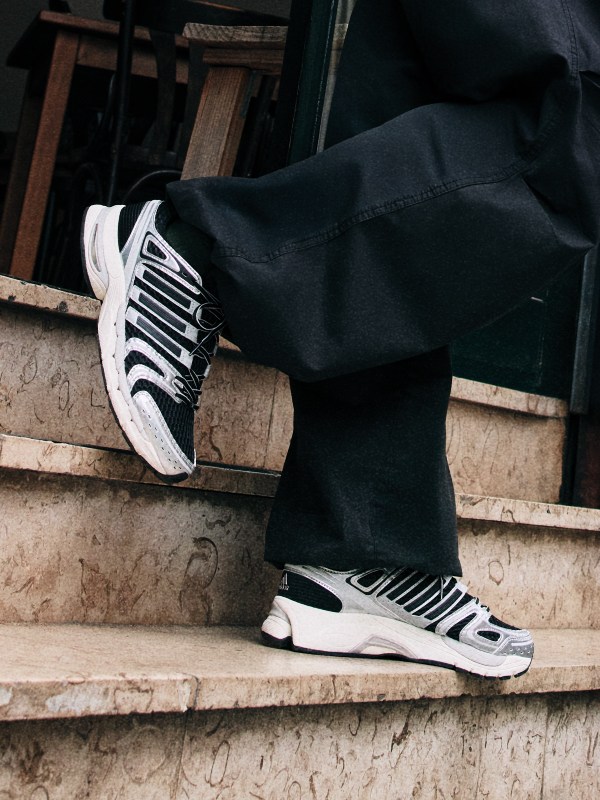 Čierno-biele tenisky na pozadí s tmavým pozadím, ktoré symbolizujú kryté prostredie.