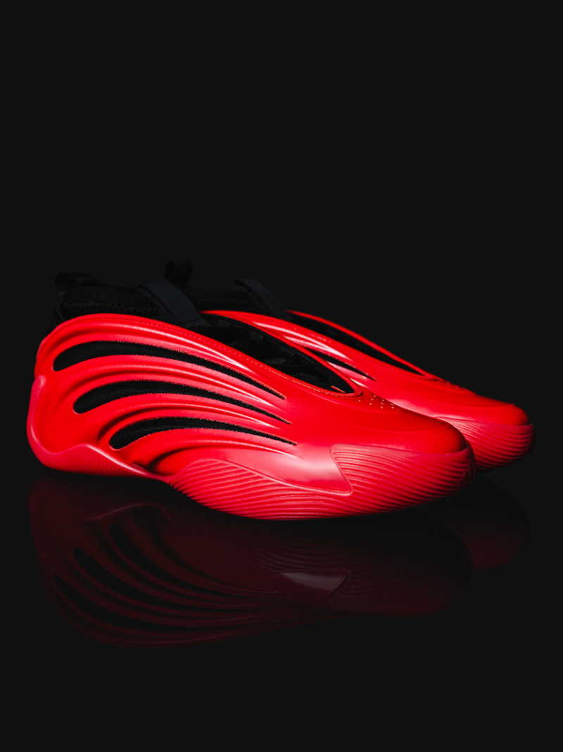 A striking, red, futuristic-looking shoe or sneaker design against a dark background, with dynamic, flowing lines and a sleek, aerodynamic appearance.