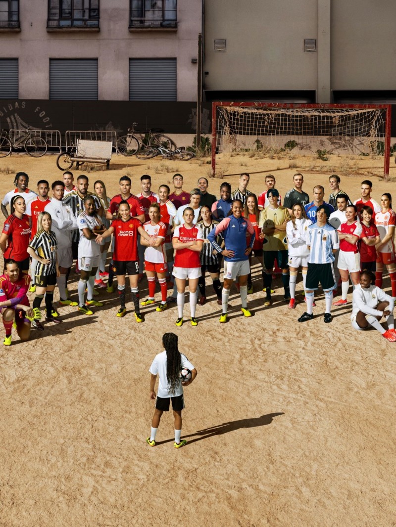 A young girl in front of the professional male and female football players