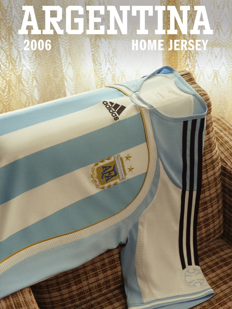 The image depicts an Argentina home jersey, featuring the Adidas logo and the Argentine national team crest, set against a background of what appears to be a woven or textured fabric.