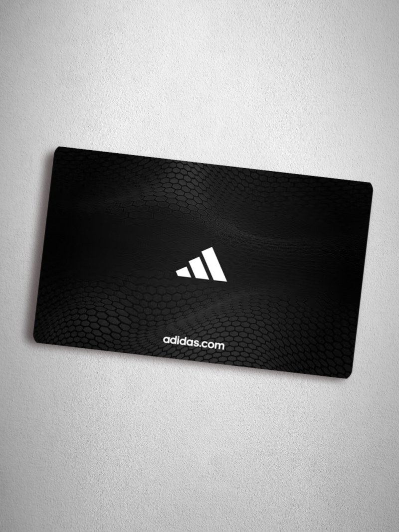 A black rectangular card with the Adidas logo and website address prominently displayed against a plain white background.