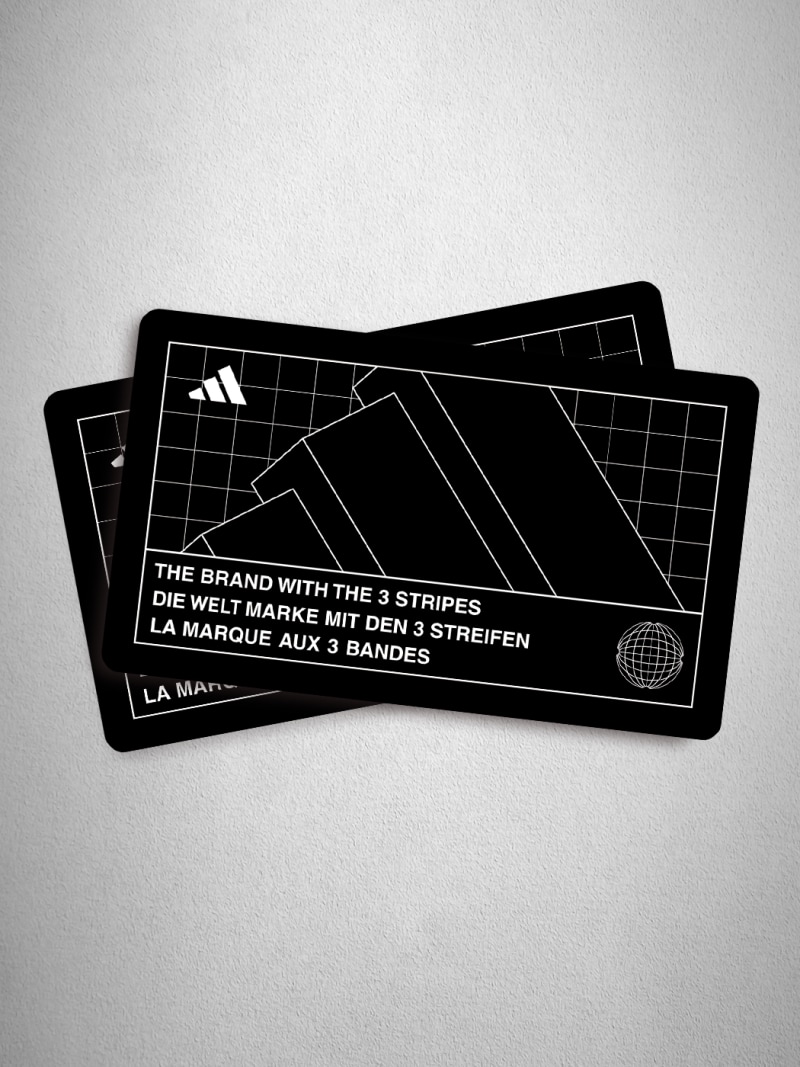 Three black and white cards with the Adidas logo and text in various languages.