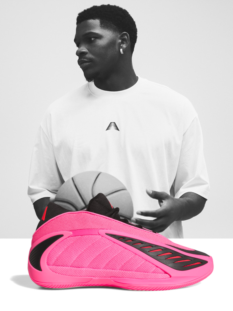 Black and white photo of Anthony Edwards wearing a white adidas t-shirt. The Xmas black red and green Anthony Edwards 2 sneaker overlaps the image.