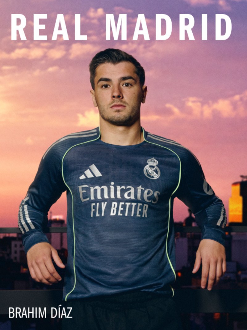 The image shows a man wearing a Real Madrid soccer jersey standing in front of a colorful sunset sky.
