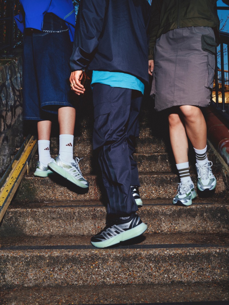 The image shows the lower bodies and feet of several people standing on a set of stairs, with colorful and stylish athletic shoes visible.