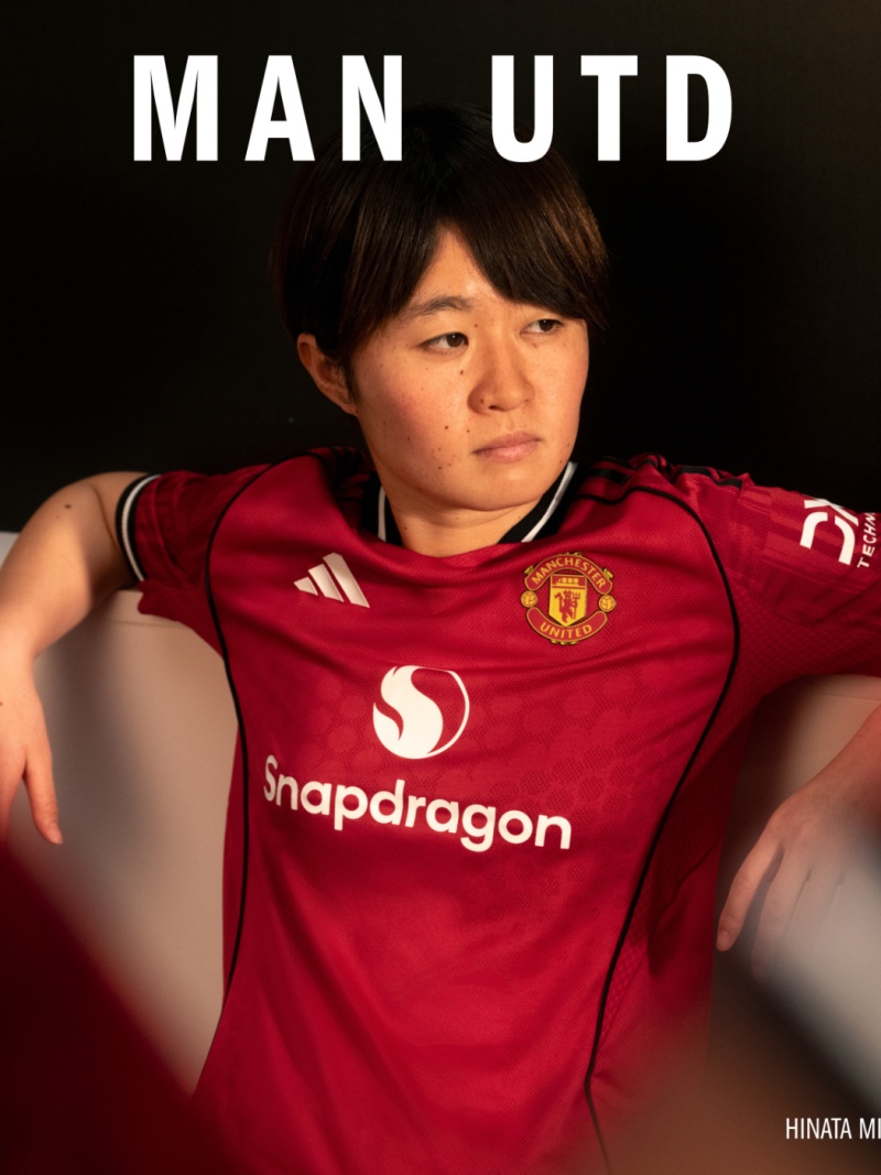 The image shows a person wearing a red Manchester United jersey with the Snapdragon logo, against a dark background.