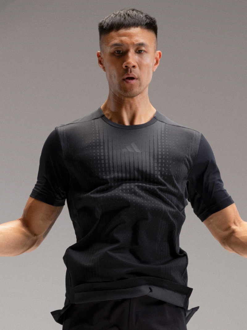 Man wearing adidas training t-shirt jumps over skipping rope.
