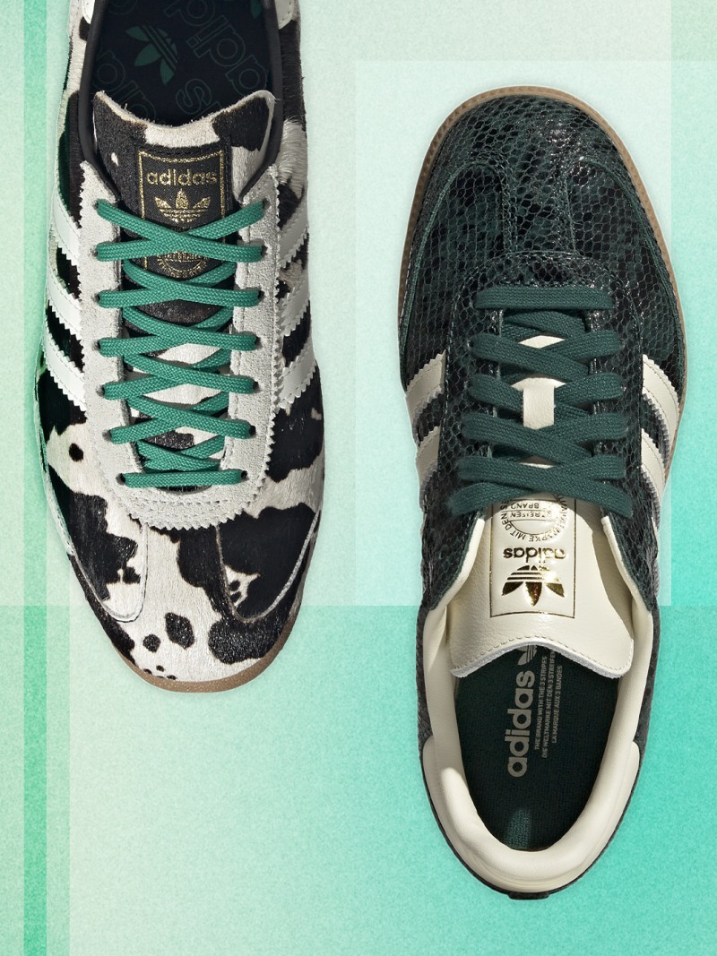 Ett par svartvita adidassneakers med gröna snören som vilar på en mintgrön bakgrund.