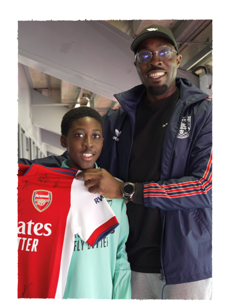An image with a boy and a man holding a football team jersey in his hands