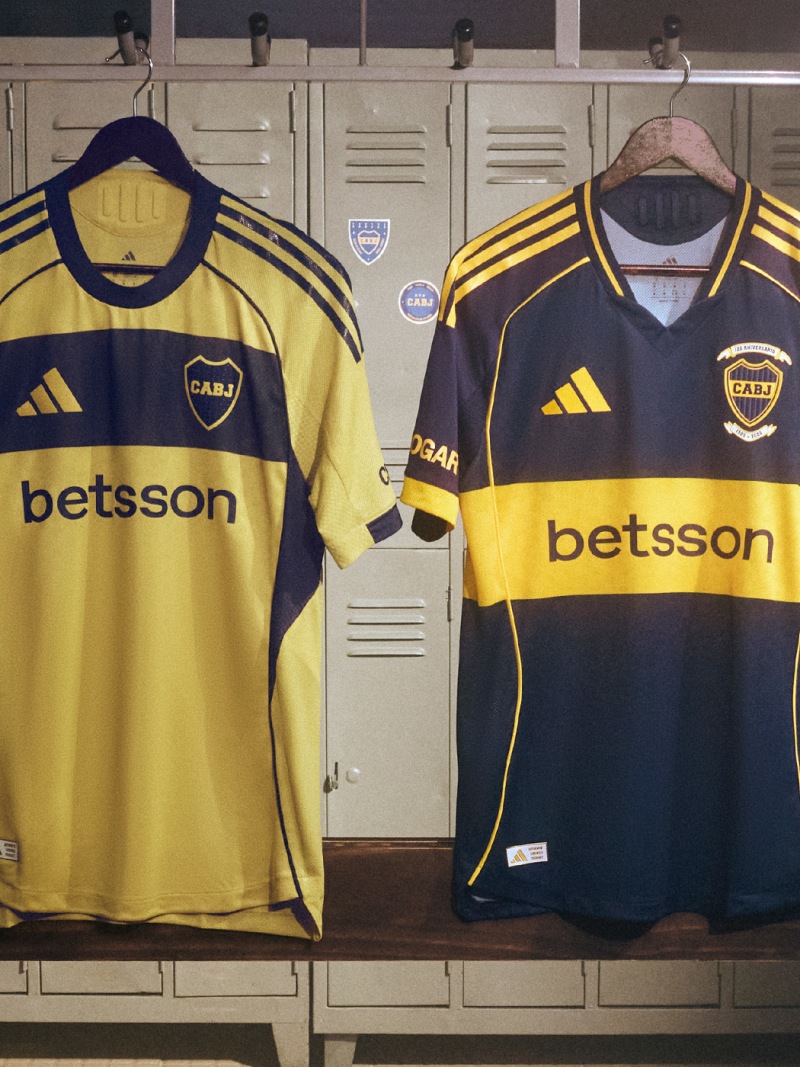 The image shows two yellow and black soccer jerseys hanging in a locker room, with lockers visible in the background.