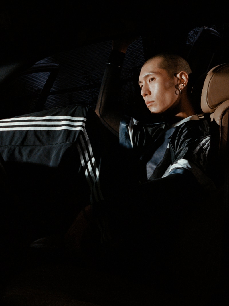 GIF of three models wearing adidas Adilenium 3.0 collection. This image features a white football jersey for women and a black football jersey for men, and a woman's denim jacket with three white stripes down the arms.