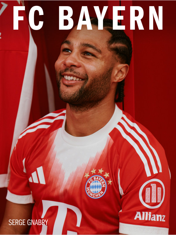A smiling man wearing a red and white soccer jersey with the FC Bayern logo and Allianz sponsor, standing in front of a red background.