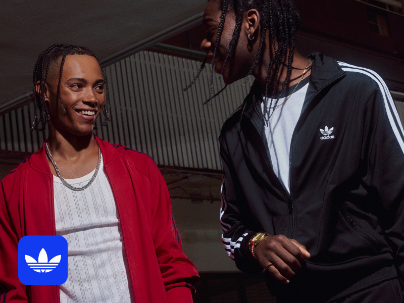 Two adiClub members talking and smiling at each other. 