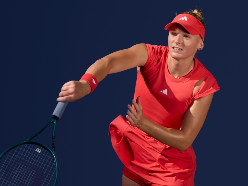 Ashlyn Krueger playing tennis, showcasing Melbourne Collection sportswear on the court.
