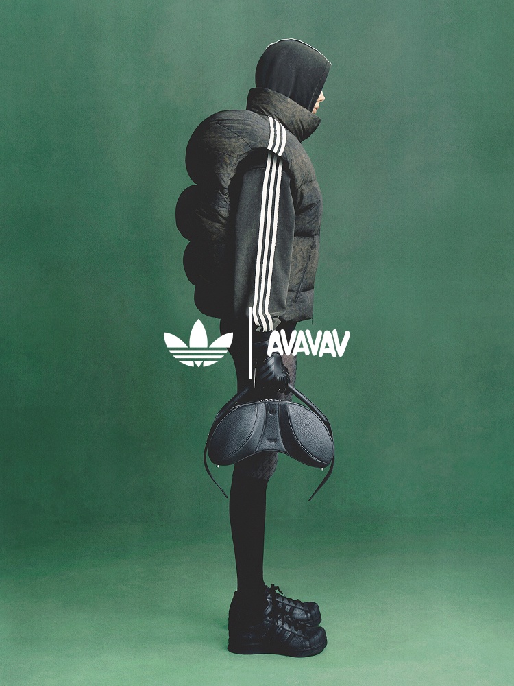 Profile of model wearing adidas Originals x Avavav, featuring black Moonrubber shoes, black sculpted leather bag, black shoulderless hoodie with white sleeve stripes, hood up, layered with a black puffer vest; a white Trefoil and Avavav logo are central.