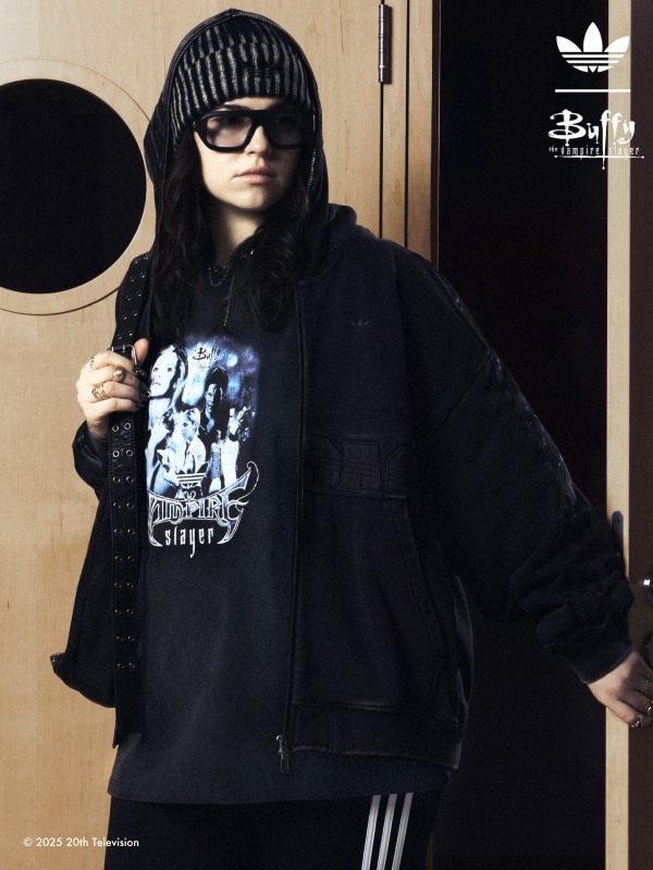 A young woman with a backpack leaving a room wearing adidas | Buffy the Vampire Slayer collection.
