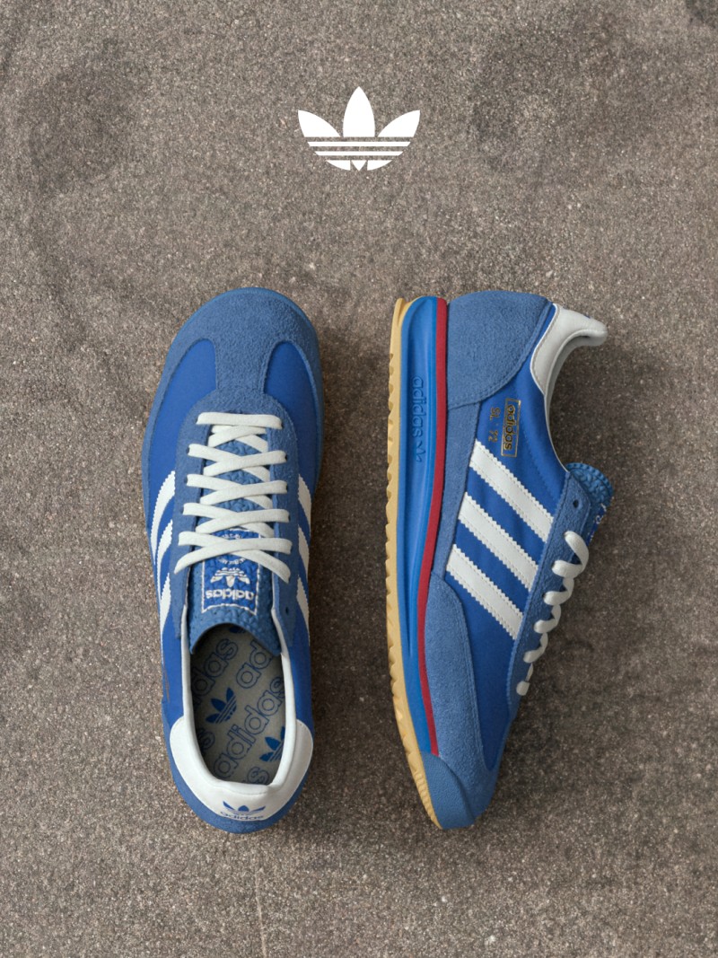 A pair of blue adidas SL 72 shoes on a concrete street. 