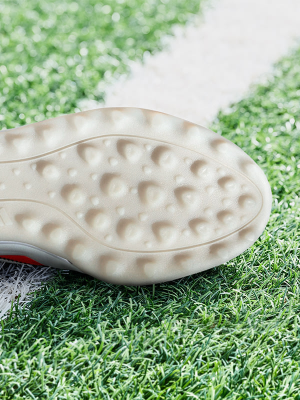 An outsole of an adidas football boot made to be played on turf