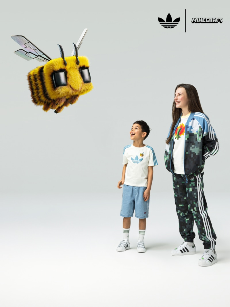 A woman and a little boy are looking at a flying Minecraft bee in awe. 