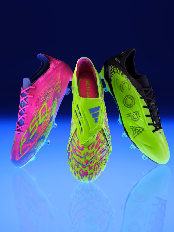 Vibrant, neon-colored soccer cleats in the foreground against a dark blue background, creating a striking visual contrast.
